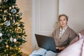 Portrait of elegant middle-aged business woman remote working or shopping online buying new year presents sitting on Royalty Free Stock Photo