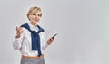 Portrait of elegant middle aged caucasian woman wearing business attire and earphones holding smartphone, smiling away