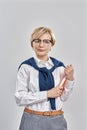 Portrait of elegant middle aged caucasian woman wearing business attire and glasses looking at camera, holding her Royalty Free Stock Photo