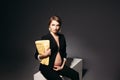 Elegant pregnant woman sitting against black studio background. Royalty Free Stock Photo