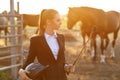 Rider woman with whip at the sunset