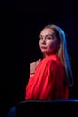 Portrait of elegant woman with long hair in red dress and dark background. Model posing doring studio photo shot Royalty Free Stock Photo