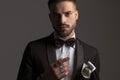 Portrait of elegant young groom in black tuxedo indicating to side Royalty Free Stock Photo