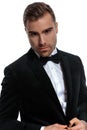 Portrait of elegant young man buttoning black tuxedo Royalty Free Stock Photo