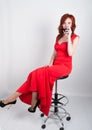 Portrait of Elegant young redhead woman in a red dress, having a glass of red wine Royalty Free Stock Photo