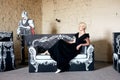 Portrait of an elegantly beautiful young woman posing on an cardboard antique couch. Royalty Free Stock Photo