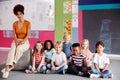 Portrait Of Elementary School Pupils Sitting On Floor In Classroom With Female Teacher Royalty Free Stock Photo