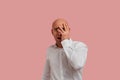 Portrait of emotional bald guy with bristle holding his hand on cheek and covering his eye by palm. Look with eyes full Royalty Free Stock Photo