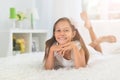 Emotional beautiful little girl posing at home on bed