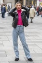 an emotional hipster woman 40-45 years old in a hat on a blurry background of the city and people passing by, Royalty Free Stock Photo