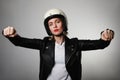 Portrait of emotional caucasian young biker woman wearing motorcycle helmet, pretending drive a bike. Isolated. Royalty Free Stock Photo