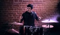 Portrait of emotional drummer rehearsing on drums before rock co