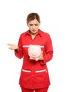 Portrait of emotional female emergency doctor with piggy bank Royalty Free Stock Photo