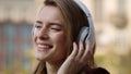 Happy woman listening music headphones outdoors. Smiling girl dancing on street. Royalty Free Stock Photo