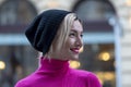 Portrait of an emotional hipster woman 40-45 years old in a hat on a blurry background of the city. Royalty Free Stock Photo