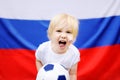 Portrait of emotional little boy with russian flag on background