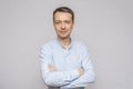 Portrait of an emotional man 30-35 years old in a light shirt, looking into the camera, on an isolated gray background. Royalty Free Stock Photo