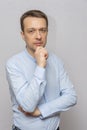 Portrait of an emotional man 30-35 years old in a light shirt, looking into the camera, on an isolated gray background. Royalty Free Stock Photo