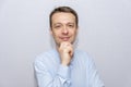 Portrait of an emotional man 30-35 years old in a light shirt, looking into the camera, on an isolated gray background. Royalty Free Stock Photo