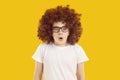 Portrait of emotional teen boy wearing curly brown wig