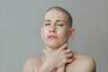 Young slender woman after chemotherapy without hair on her head, strangles herself with her hands Royalty Free Stock Photo