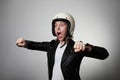 Portrait of emotional young biker woman wearing motorcycle helmet, pretending drive a bike. Isolated. Royalty Free Stock Photo