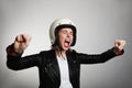 Portrait of emotional young biker woman wearing motorcycle helmet, pretending drive a bike. Isolated. Royalty Free Stock Photo