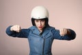 Portrait of emotional young biker woman wearing motorcycle helmet, pretending drive a bike. Pink background. Isolated. Royalty Free Stock Photo