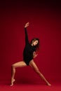 Portrait of emotional young flexible contemp dancer, ballerina dancing  on dark red background. Art, beauty Royalty Free Stock Photo