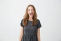 Portrait of emotive young beautiful girl shouting with closed eyes over white background. Royalty Free Stock Photo