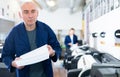 Portrait of an employee of printing house with stack of paper in his hands