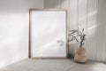 Portrait empty wooden frame mockup in sunlight. Olive branch in modern organic shaped vase. Beige linen table cloth Royalty Free Stock Photo