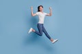 Portrait of energetic carefree excited lady jump run winner concept on blue background