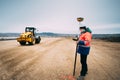 Portrait of engineer on construction site, surveyor using gps system and theodolite on highway construction site