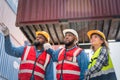 Portrait of Engineer or foreman team pointing up the future with cargo container background at sunset. Logistics global import or Royalty Free Stock Photo