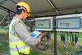 Portrait of engineer man or worker, people, with solar panels or solar cells on the roof in farm. Power plant with green field, Royalty Free Stock Photo