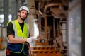 Portrait of engineer or technician worker point ot lower parts of electric train and also look at camera with confidence action in Royalty Free Stock Photo