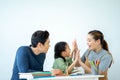 Portrait enjoy happy smiling Asian family mother and father with little daughter sit at desk learning and making homework spending Royalty Free Stock Photo