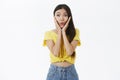 Portrait of enthusiastic excited and intrigued charming female shopoholic in yellow trendy t-shirt folding lips from Royalty Free Stock Photo