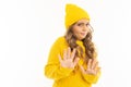 Portrait of european attractive girl in a yellow hat shows discontent with hands on a white background with copyspace Royalty Free Stock Photo