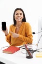 Portrait of european customer supporter woman holding smartphone while working in call center