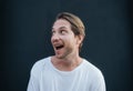 Portrait of european happy man in white t0shirt at dark wall