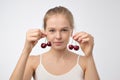 Portrait of european young woman holding red cherry. Royalty Free Stock Photo