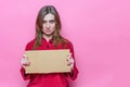 Portrait evil beautiful young brunette girl with long haire in red pajamas with a cardboard sign in hands. Template