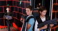 excited teen boy and girl aiming laser gun at other players Royalty Free Stock Photo