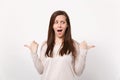 Portrait of excited amazed beautiful young woman in light clothes pointing thumbs aside isolated on white wall