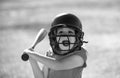 Portrait of excited amazed kid baseball player wearing helmet and hold baseball bat. Funny kids sports face. Royalty Free Stock Photo