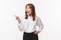 Portrait of excited and amused elegant young asian woman in white office shirt, pointing looking finger left and smiling Royalty Free Stock Photo