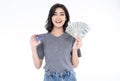 Portrait of an excited Asian woman holding bunch of money banknotes and showing credit card isolated over white background. Royalty Free Stock Photo