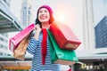 Portrait of an excited beautiful young girl wear shirt and wool hat holding many shopping bags and smile. With copy space. Royalty Free Stock Photo